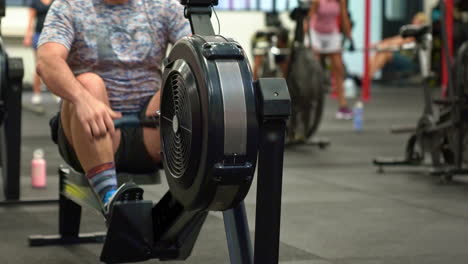 Male-athlete-on-Rowing-Machine-in-busy-gym