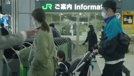 People-Wearing-Masks-Tapping-Smartphones-To-Pass-Through-Automatic-Ticket-Gates-At-Shinagawa-JR-Station-In-Tokyo---medium-shot,-slow-motion