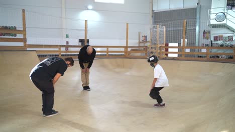 Group-of-different-ages-warming-up-knees-inside-skateboard-park