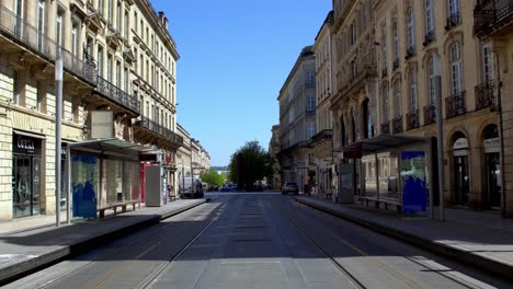 Cours-de-l'Intendance-avenue-with-trolley-tracks-leading-to-the-Opera-House-deserted-due-to-the-COVID-19-pandemic,-Dolly-forward-walking-shot