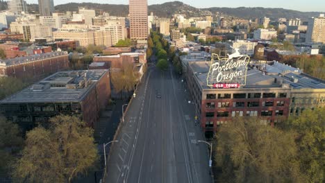 Wide-and-majestic-aerial-shot-revealing-Portland,-Oregon's-iconic-Old-Town-sign-with-empty-streets-due-to-COVID-19