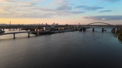Drone-shot-of-the-city-of-Kiev-with-the-Dnipro-river-and-some-bridges-during-the-sunset
