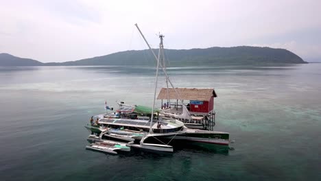 Erleben-Sie-Ein-Ausflugsboot-Im-Raja-Ampat-Archipel-In-Indonesien,-Das-Gäste-Zu-Einer-Schnorcheltour-Mitnimmt,-Aufnahme-Vom-Sockel-Aus-Der-Luft