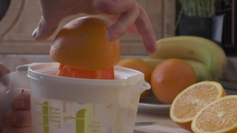 Orangensaft-Mit-Einer-Plastikpresse-Von-Hand-Auspressen,-Um-Morgens-Ein-Erfrischungsgetränk-Zu-Erhalten