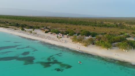 Aerial-view-of-Eco-del-Mar-exclusive-natural-lodge-with-ecological-tent-accommodations-by-turquoise-sea-water,-Dominican-Republic,-overhead-circle-aerial