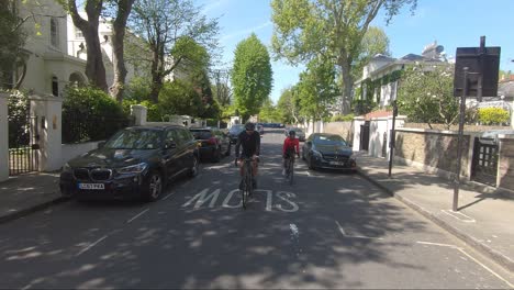 Two-Cyclists-Riding-Down-Park-Place-Villas-Road-In-Maida-Vale-During-Lockdown-In-London