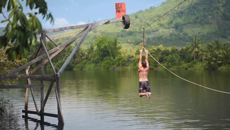 Ein-Tourist-Springt-In-Kambodscha-Von-Einer-Seilrutsche-Ins-Wasser