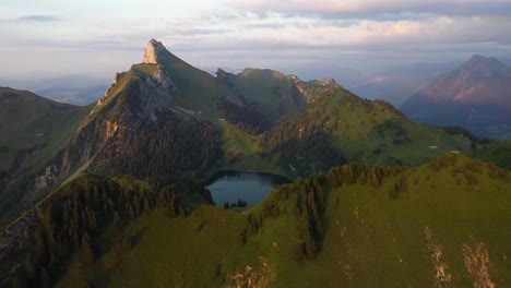 Slow-and-steady-drone-shot-of-the-top-of-Stockhorn,-Switzerland-with-a-small,-pretty-lake-among-sharp-and-dramatic-edges-of-cliffs-and-peaks