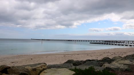Busselton-wooden-Jetty-and-beach-on-cloudy-day,-Western-Australia