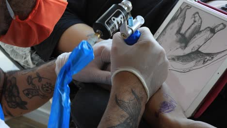 Tattoo-artist-making-its-draw-on-an-arm