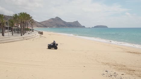 Still-shot-empty-beach-with-patrol-police-passing-by-on-quad