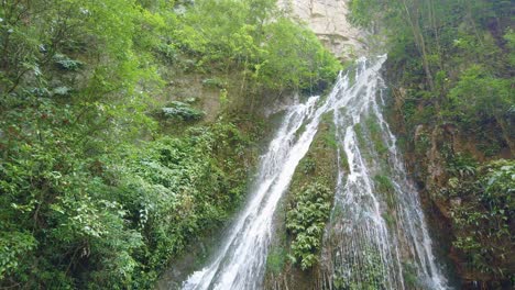 Large-scenic-waterfall-falling-down-steep-high-wall-of-the-deep-gorge-in-Wulong-National-Park,-China