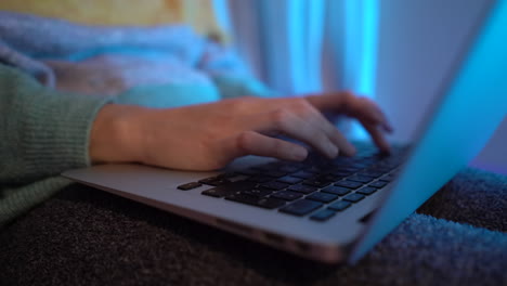 Typing-on-the-computer-at-night,-while-sitting-in-bed
