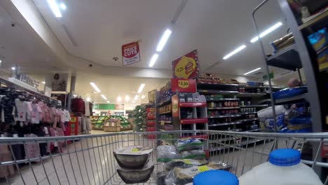 Inside-supermarket-shopping-cart-pushing-trolley-down-international-foods-aisle-as-customers-shop-during-corona-virus-pandemic