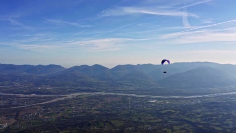 colorful-paraglider-in-air-with-Piave-river-in-background,-adventure-sport