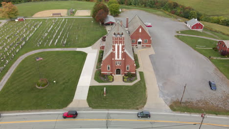 An-aerial-establishing-shot-of-a-typical-red-brick-church-in-the-Pennsylvania-countryside-in-the-autumn