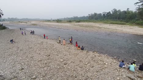 Tourists-sitting-at-bank-of-small-flowing-river-at-daytime