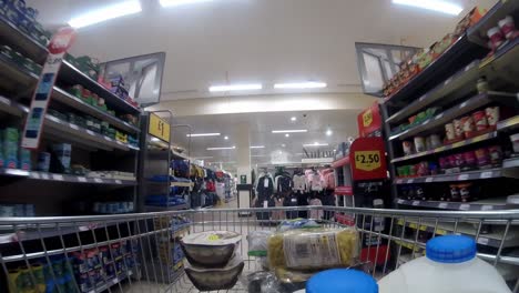 Inside-supermarket-shopping-cart-pushing-trolley-down-soup-aisle-as-customers-shop-during-corona-virus-pandemic