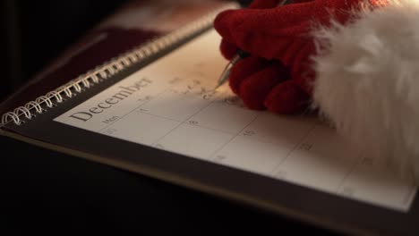 Der-Weihnachtsmann-Schreibt-Zu-Weihnachten-In-Den-Kalender,-Mittlere-Schwenkaufnahme