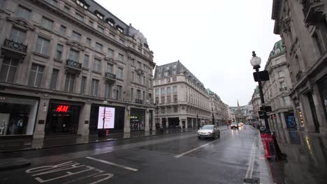 Oxford-Circus-shopping-street-and-intersection,-almost-completely-empty-in-the-middle-of-the-day-on-a-Friday