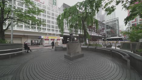 Pocas-Personas-Que-Vienen-A-La-Estación-De-Tren-De-Shibuya-Cerca-De-La-Famosa-Estatua-De-Hachiko-En-Tokio,-Japón,-Bajo-Bloqueo-Mundial---Brote-De-Coronavirus---Plano-General