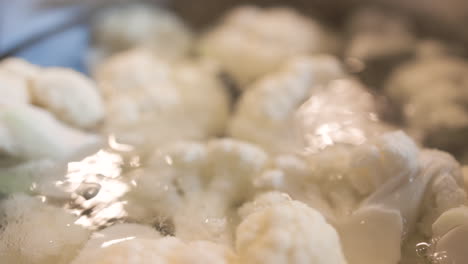 Close-up-of-Cauliflower-in-boiling-bubbling-water-shimmering-with-light-reflecting-off-the-water