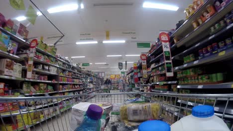 Inside-supermarket-shopping-cart-pushing-trolley-down-baking-aisle-as-customers-shop-during-corona-virus-pandemic