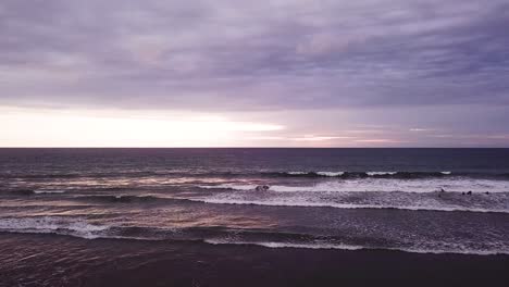 Menschen,-Die-Bei-Sonnenuntergang-Am-Violetten-Olon-Strand-Von-Ecuador-Spazieren---Luftaufnahmen