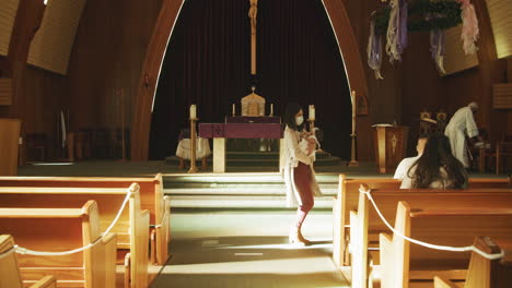 Aisle-of-a-Catholic-Church-with-Masked-Mother-Carrying-Baby-during-COVID-19-Coronavirus-Pandemic-in-Slow-Motion
