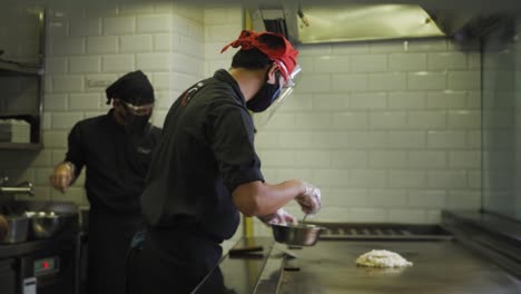 Koch-Trägt-Maske-Und-Gesichtsschutz-In-Der-Küche-Und-Kocht-Während-Einer-Pandemie-Japanisches-Okonomiyaki-Im-Teppanyaki-Grill