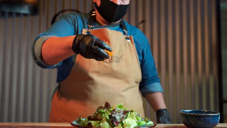 Chef-with-gloves-throw-carrow-to-salad