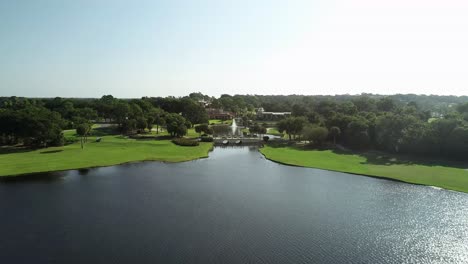 Aerial-View-Over-Peaceful-Lake-Toward-Mission-Inn-Resort-in-Howey-In-The-Hills,-FL
