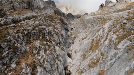 Bergaufflug-Entlang-Eines-Flusses,-Der-In-Die-Felswand-Eines-Berges-Eingeschnitten-Ist