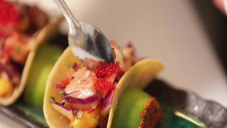 Chef-In-The-Kitchen-Putting-Red-Caviars-On-Top-Of-Sushi-Tacos-Using-A-Teaspoon