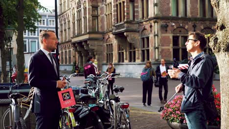 Dos-Hombres-Holandeses-Debatiendo-Al-Aire-Libre-En-La-Haya,-Países-Bajos