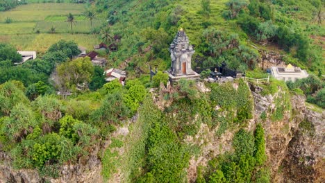 Buddhist-temple-aerial-dolly-out-to-reveal-cliff-and-Ngobaran-beach,-Indonesia