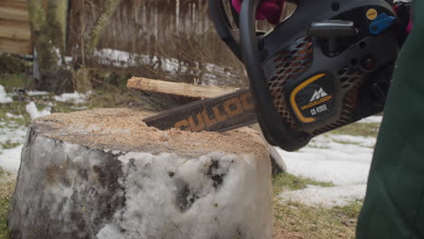 Medium-close-up-of-a-running-chainsaw-cutting-a-piece-of-wood-on-the-ground