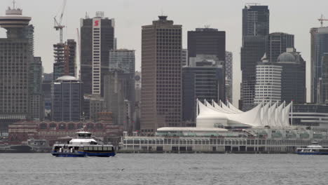 SeaBus-Crosses-At-Burrard-Inlet-With-Metro-Vancouver-And-Canada-Place-In-Background