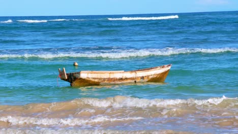 Barco-De-Pescadores-Listo-Para-Salir-A-Buscar-El-Sustento-De-Su-Familia,-Día-Soleado,-Olas-Brillantes-En-La-Playa-Azul