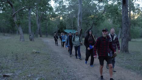 Grupo-De-Hombres-Caminando-En-Línea-Llevando-Una-Cuerda-Larga-Y-Gruesa---Yendo-A-Un-Camping---Monte-Byron-En-Queensland,-Australia