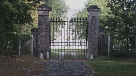 slow-dolly-towards-large-old-closed-gate-of-mansion-castle