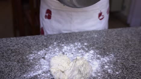 Pastry-chef-taking-mixed-dough-ingredients-out-of-bowl-ready-for-kneading