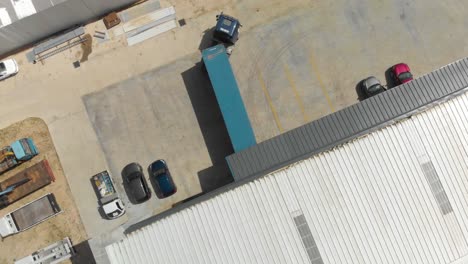 Blue-container-truck-reversing-into-a-warehouse