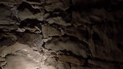 Muro-De-Piedra-Espeluznante-En-El-Sótano-De-Un-Edificio-Antiguo-De-Cerca-Toma-Panorámica