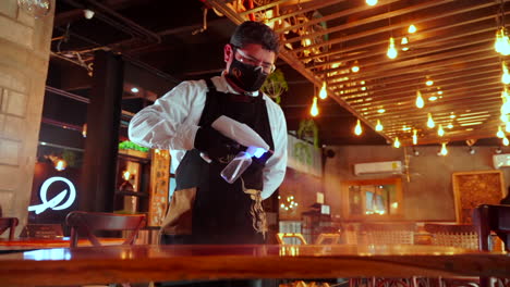 Camarero-Usando-Pistola-De-Dispositivo-Desinfectante-A-Cámara-Lenta-En-El-Bar-Del-Restaurante
