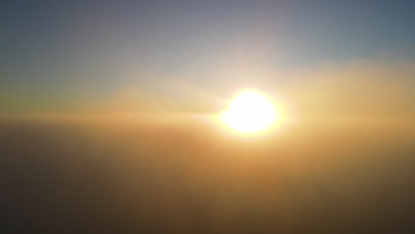 Sunrise-Sun-Rays-in-Foggy-Hazy-Clouds---Aerial-Helicopter-View