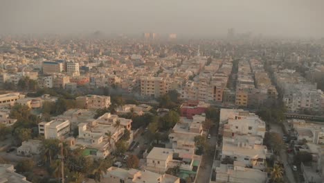 Antena-Sobre-Karachi-Llena-De-Smog-Con-Un-Tren-Que-Pasa-Por-Debajo