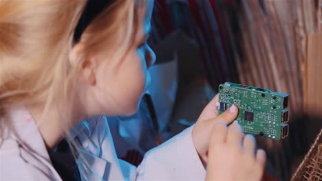Smart-Young-Girl-Fixing-The-Motherboard-Of-A-Raspberry-Pi---close-up
