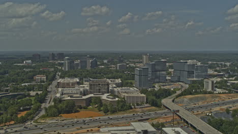 Atlanta-Georgia-Aerial-v675-pan-left-shot-from-afar-of-freeway-under-construction,-green-space-and-cityscape---DJI-Inspire-2,-X7,-6k---August-2020