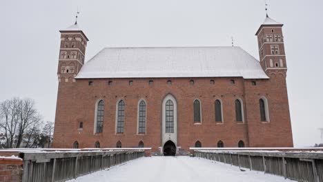 Snow-Covered-Pathway-And-Structure-Facade-Of-Lidzbark-Bishops'-Castle-In-Lidzbark-County,-Poland-Near-Hotel-Krasicki